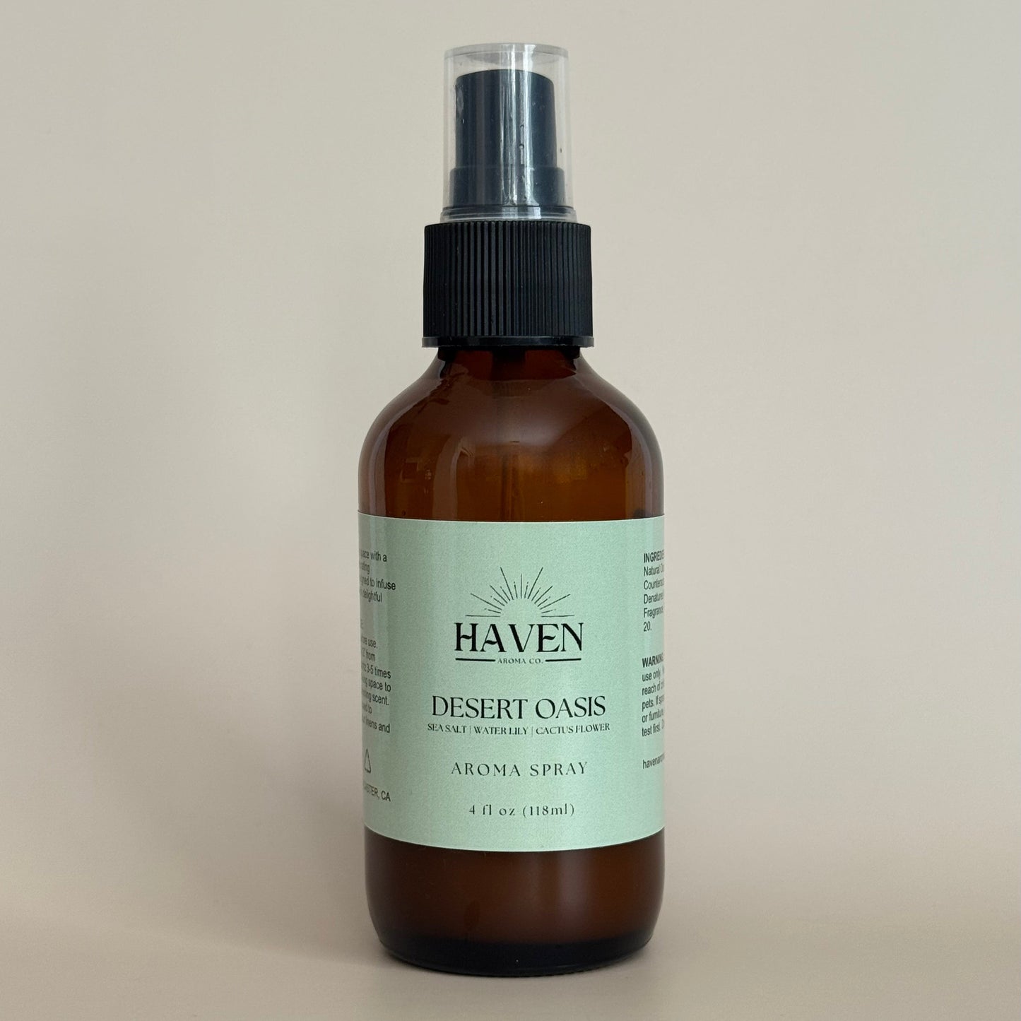 Amber spray bottle labeled 'Haven Desert Oasis' on a beige background