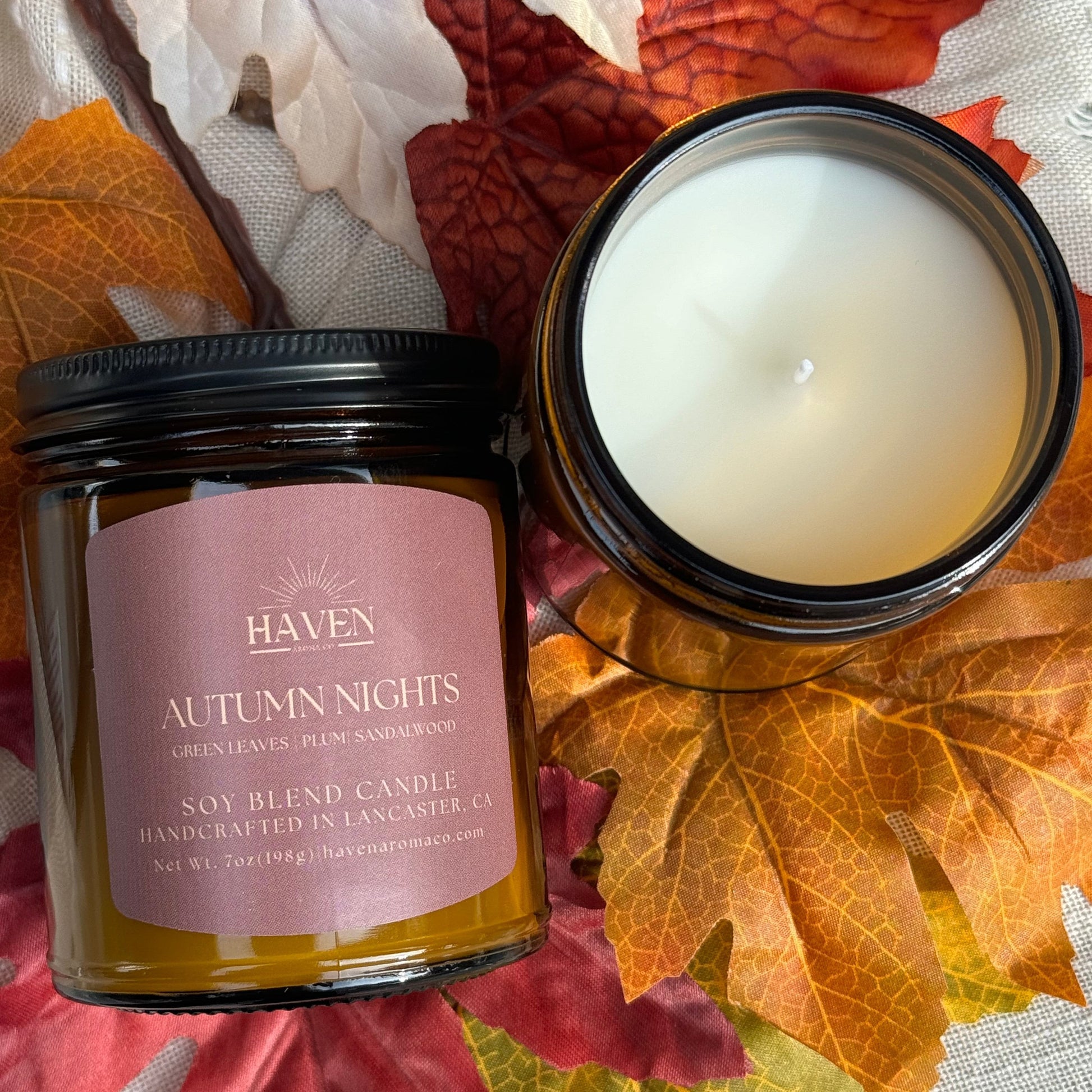 Candle with label that says Autumn Nights with scent of Green Leaves, Plum and Sandalwood