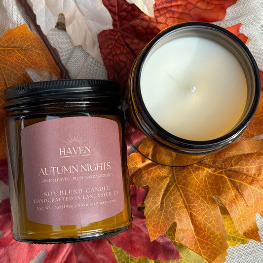 Candle with label that says Autumn Nights with scent of Green Leaves, Plum and Sandalwood
