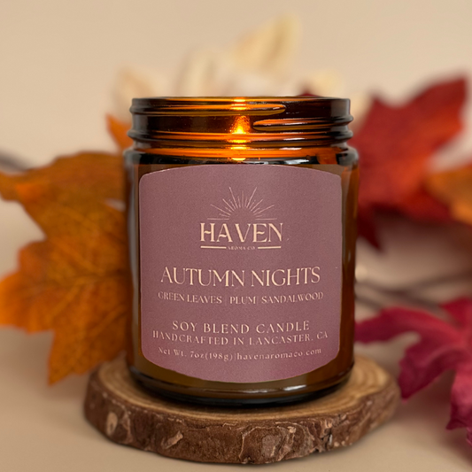 Haven Autumn Nights candle with fall leaves in the background