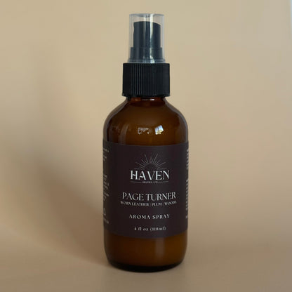 Amber aroma spray bottle with black label on a beige background